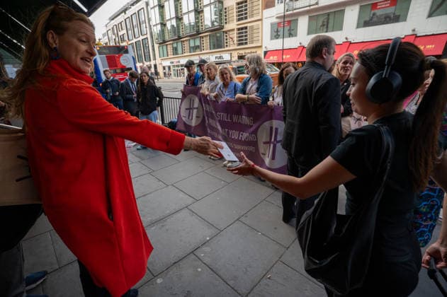 September 18, 2026, London, United Kingdom: A protester hands out leaflets during a demonstration outside the main entrance to the Harrods department store in Knightsbridge. Survivors of alleged sexual abuse by former Harrods owner Mohamed Al Fayed and their supporters hold a demonstration outside Harrods department store in Knightsbridge, London. Protesters held placards, handed leaflets to members of the public and stood behind a large campaign banner outside the store entrance. The survivors are calling for the findings of a previous inquiry into allegations against Al Fayed to be made public and for a further public inquiry to examine the allegations and establish the truth surrounding the claims. London United Kingdom  - ZUMAs197 20260918_aaa_s197_021 Copyright: xJamesxWilloughbyx