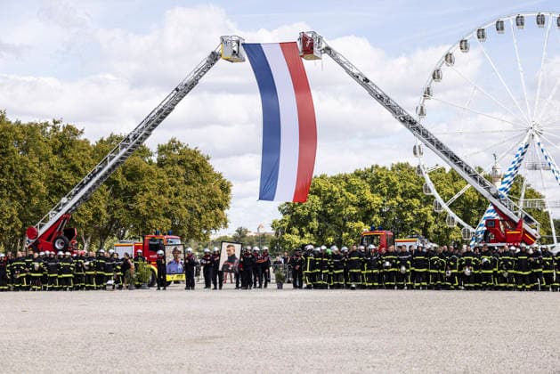 Laurent Nunez Presides Over A Tribute To Two Firefighters Who Died In Wildfires - Bordeaux Bordeaux, Gironde, Nouvelle-Aquitaine, France, September 18, 2026. Firefighters gather beneath a large French flag suspended between two aerial ladders operated by the Gironde Departmental Fire and Rescue Service (SDIS 33) during the national tribute to adjudants Anthony Berthome and Wilfried Schmitter. Photo by Stephane Duprat ABACAPRESS.COM Bordeaux NOUVELLE-AQUITAINE France  Copyright: xDupratxStephane ABACAx