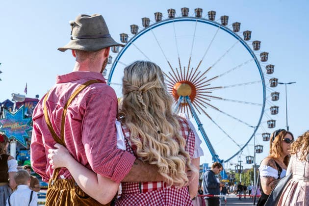 Oktoberfest 2026, Wiesn kicks off under bright sunshine and temperatures up to 24 degrees—perfect Wiesn weather; a couple in traditional dress in front of the Ferris wheel, opening day, September 19, 2026, Germany, Munich, September 19, 2026, Oktober