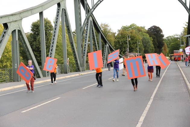 Protesters hold up signs that, when put together, spell out the words Education and Democracy during a protest under the slogan Education Needs Democracy, Democracy Needs Education on the Glienicker Bridge between Berlin and Potsdam, September 19, 2026. Education Policy Protest on the Glienicker Bridge