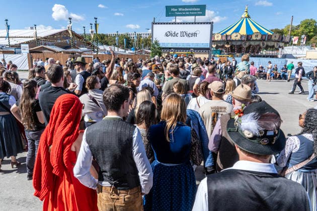 Oktoberfest 2026, a crowd gathered at the entrance to the Oide Wiesn shortly after noon, Wiesn kicks off under bright sunshine and temperatures up to 24 degrees—perfect Wiesn weather; a couple in traditional dress in