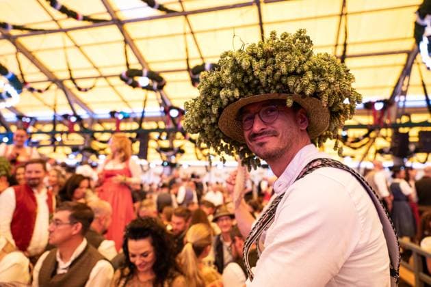 (260919) -- MUNICH, Sept. 19, 2026 -- A man wearing a hat decorated with hops is pictured at the Oktoberfest in Munich, Germany, Sept. 19, 2026. The 191st Oktoberfest, one of the largest folk festivals in Germany, opened on Saturday in Munich, with mayor Dominik Krause tapping the first barrel of beer as a tradition. This year s festival will last until Oct. 4. ) GERMANY-MUNICH-OKTOBERFEST-OPENING ZhangxHaofu 