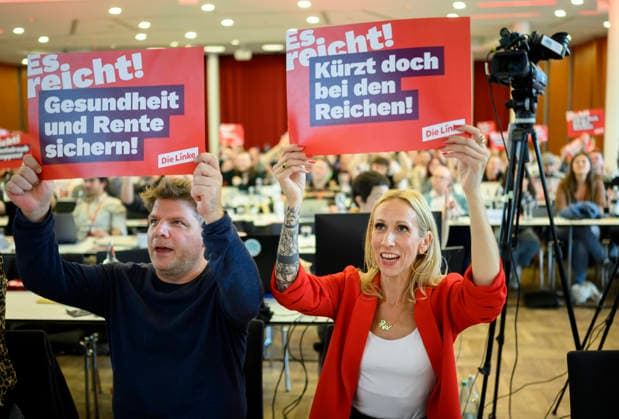 From left to right: Sebastian Merkens, state executive director and lead candidate, and Alexandra Mehdi, lead candidate for the 2027 North Rhine-Westphalia state election, hold up posters reading Secure Health Care and Pensions—Cut Taxes for the Rich, Enough is enough, on September 19, 2026, at The Left NRW State Party Convention, held from September 19 to September 20, 20