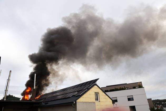 Flames and smoke are shooting out of the roof of the former Naturstein Stefan Wormser workshop building, located at Pestalozzistraße and Friedhofsweg in Pegnitz, on September 20, 2026. A solar panel system is on fire.