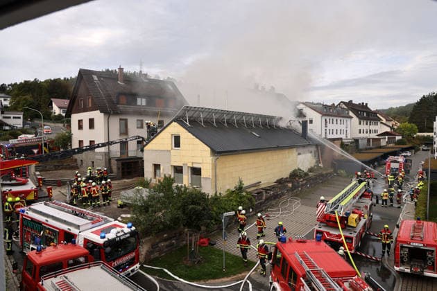 Fire trucks and firefighters on the scene at Friedhofsweg and Am Posthaler; fire at the former Naturstein Stefan Wormser workshop building on Pestalozzistraße and Friedhofsweg in Pegnitz, September 20, 2026, Upper Franconia, Bavaria,