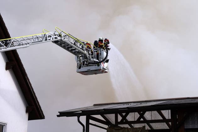 A turntable ladder on Pestalozzistrasse during firefighting operations to extinguish the fire at the former Naturstein Stefan Wormser workshop building, located at the intersection of Pestalozzistrasse and Friedhofsweg in Pegnitz, September 20, 2026, Upper Franconia, Bavaria,