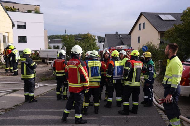 Ice-skating discussion among several firefighters; fire at the former Naturstein Stefan Wormser workshop building, Pestalozzistraße and Friedhofsweg, Pegnitz, September 20, 2026, Upper Franconia, Bavaria,
