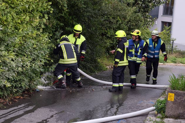 Emergency responders connect to hydrants on Friedhofsweg; fire at the former Naturstein Stefan Wormser workshop building, Pestalozzistraße and Friedhofsweg in Pegnitz, September 20, 2026, Upper Franconia, Bavaria, Volunteer Fire Department