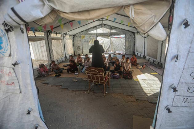Gaza Temporary Tent Classrooms Palestinian children sit facing a teacher inside a temporary classroom tent in western Gaza City, Gaza Strip on September 20, 2026. Thousands of Palestinian children in the Gaza Strip have resumed lessons in temporary classrooms as the education system continues to face widespread disruption and damage following the war. Temporary learning spaces, including tents, are being used as schools and educational facilities remain damaged or unavailable. Gaza Gaza Strip Palestinian Territories Copyright: xFaizxQreqax