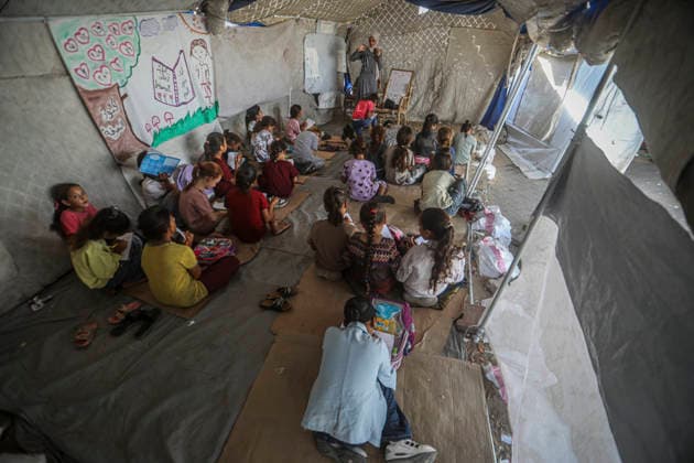 Gaza Temporary Tent Classrooms Palestinian children sit facing a teacher inside a temporary classroom tent in western Gaza City, Gaza Strip on September 20, 2026. Thousands of Palestinian children in the Gaza Strip have resumed lessons in temporary classrooms as the education system continues to face widespread disruption and damage following the war. Temporary learning spaces, including tents, are being used as schools and educational facilities remain damaged or unavailable. Gaza Gaza Strip Palestinian Territories Copyright: xFaizxQreqax