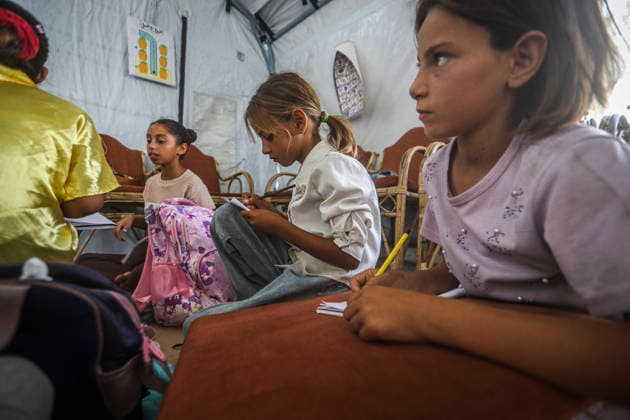 Gaza Temporary Tent Classrooms Palestinian girls sit with notebooks and school materials inside a temporary classroom tent in western Gaza City, Gaza Strip on September 20, 2026. Thousands of Palestinian children in the Gaza Strip have resumed lessons in temporary classrooms as the education system continues to face widespread disruption and damage following the war. Temporary learning spaces, including tents, are being used as schools and educational facilities remain damaged or unavailable. Gaza Gaza Strip Palestinian Territories Copyright: xFaizxQreqax
