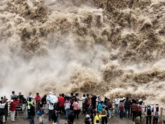 YAN AN, CHINA - SEPTEMBER 20: Tourists visit the Hukou Waterfall on the Yellow River as water volume significantly increases due to sediment discharge and flood release from upstream reservoirs on September 20, 2026 in Yan an, Shaanxi Province of China. The waterfall s flow rate reached 1,800 cubic meters per second, with the main and side falls merging into a continuous line.  Copyright: xVCGx 111668265432