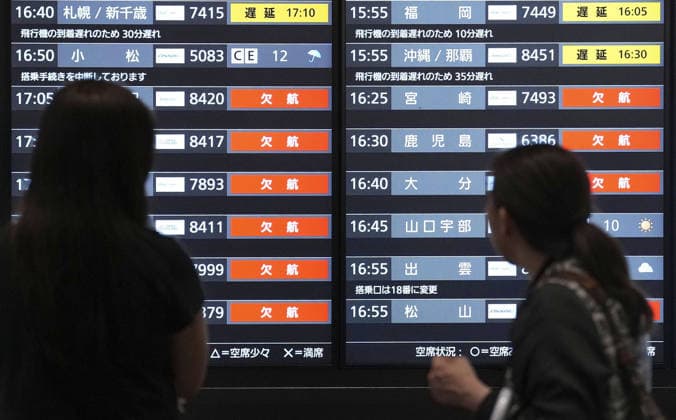 Typhoon approaches eastern Japan Passengers look at a flight information board showing flight delays and cancellations at Tokyo s Haneda airport on Sept. 21, 2026, amid the approach of Typhoon Dujuan.  A14AA0005628159P