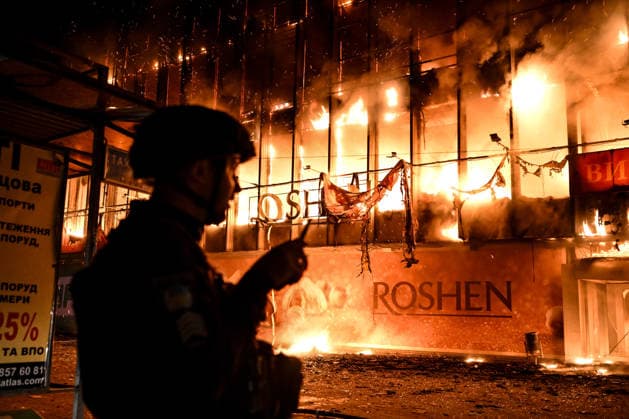 A law enforcer stands in front of the burning Intrade shopping centre that caught fire due to an overnight Russian drone attack, Zaporizhzhia, Ukraine, September 21, 2026. On Monday night, Russian forces struck the southeastern city with strike UAVs and an FPV drone. The attack destroyed the shopping centre and damaged a university building as well as multi-storey residential blocks. Six people were injured. (Photo by Dmytro Smolienko Ukrinform) Russian army attacks shopping mall with drones in Zaporizhzhia  Copyright: xDmytroxSmolienkox