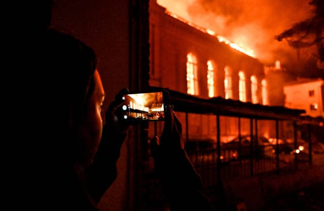 Historic building of Zaporizhzhia National University struck by Russian army A woman films Academic Building No. 3 of Zaporizhzhia National University, which caught fire in an overnight Russian drone attack, in the Oleksandrivskyi district of Zaporizhzhia, Ukraine, September 21, 2026. The building, a cultural heritage site and architectural monument of local significance, was formerly the Oleksandrivsk Girls™ Gymnasium, built in 1902. A significant portion of the historic structure burned down in the attack. Buildings No. 4 and No. 5 also sustained damage, with windows shattered. The Russian strike additionally destroyed a shopping centre and damaged multi-storey residential blocks. Six people were injured., Credit:Dmytro Smolienko Ukri Copyright: xDmytroxSmolienkox xUkrinformx xAvalonx 1137024959