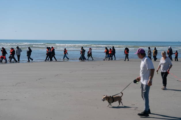 September 21, 2026, Berck, Nord France, France: Berck, France. Dog walkers watch migrants as they arrive at the beach at Berck-sur-Mer, in northern France, before attempting to cross the English Channel Berck France  - ZUMAl94_ 20260921_zaf_l94_054 Copyright: xIoannisxAlexopoulosx