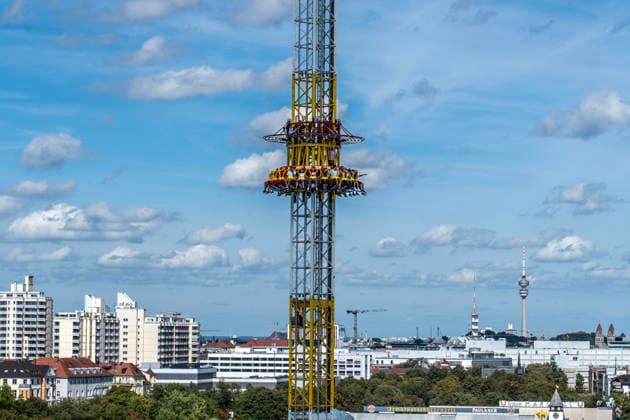 Oktoberfest 2026, a panoramic view from the Ferris wheel over the Hangover ride to the horizon with the Olympic Tower; the Wiesn kicks off under bright sunshine and temperatu