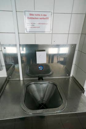 CNTV DROBINN Interior view of a sign on the wall at the Dron Inn in Hamburg, dated September 21, 2026, with the message Please do not throw anything into the vomit basin. Drob Inn is a contact and counseling center with integrated drug consumption rooms in Hamburg, Germany.