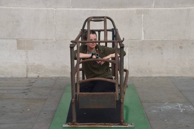 September 22, 2026, London, England, United Kingdom: The activist MICHELLE FARNHAM sits inside a farrowing crate in Trafalgar Square on the final day of a protest against pig crates and factory farms organised by the animal rights group Animal Rising. The activist lived in the crate for three weeks, demonstrating how mother pigs live on factory farms, and calling for an end to farrowing crates and a pig named Luna to be freed. London United Kingdom - ZUMAv130 20260922_zip_v130_008 Copyright: xVukxValcicx