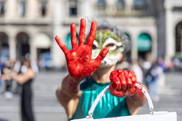 IPA88825802 - Milan, September 22, 2026, Piazza del Duomo, start of Fashion Week: a PETA animal rights flash mob featuring two women wearing crocodile masks and with their hands painted red to denounce the violence against exotic animals used in the manufacture of leather shoes, belts, and handbags  Copyright: xFrancescoxEnriquezx xFrancescoxEnriquezx IPA88825802