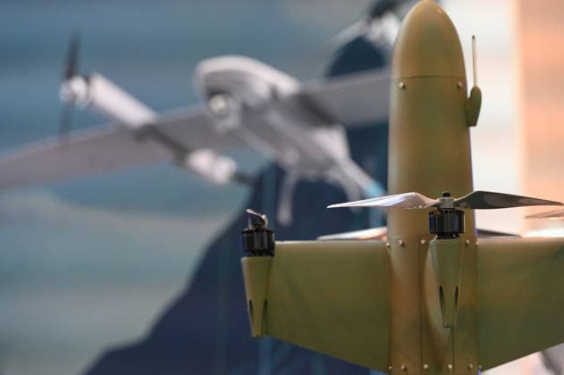 Model of a drone, with a drone on a poster in the background; EUDEX Euro Defense Expo, September 22, 2026, at Messe Essen, Germany