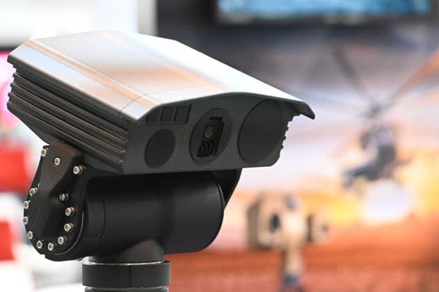 Reconnaissance system, thermal imaging camera, detectors; in the background, a poster featuring a combat helicopter; EUDEX Euro Defense Expo, September 22, 2026, at Messe Essen, Germany