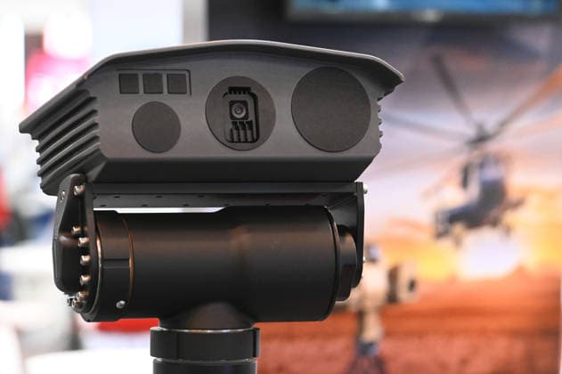 Reconnaissance system, thermal imaging camera, detectors; in the background, a poster featuring a combat helicopter; EUDEX Euro Defense Expo, September 22, 2026, at Messe Essen, Germany