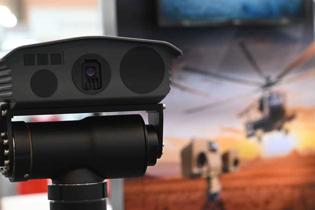 Reconnaissance system, thermal imaging camera, detectors; in the background, a poster featuring a combat helicopter; EUDEX Euro Defense Expo, September 22, 2026, at Messe Essen, Germany