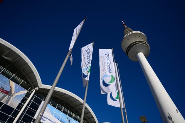 WindEnergy Hamburg with the Heinrich Hertz Tower, Hamburg, Germany; WindEnergy Hamburg flags in front of the exhibition halls at Hamburg Messe, with the Heinrich Hertz Tower in the background against a blue sky. WindEnergy Hamburg is an international trade fair for the wind energy industry. Hamburg, Germany 20260922_Z9B_6860