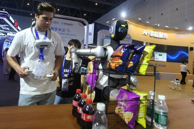 HANGZHOU, CHINA - SEPTEMBER 23: A foreign visitor trains a humanoid robot to sort goods at the fifth Global Digital Trade Expo on September 23, 2026 in Hangzhou, Zhejiang Province of China. The expo focuses on frontier artificial intelligence technologies.  Copyright: xVCGx 111669003016