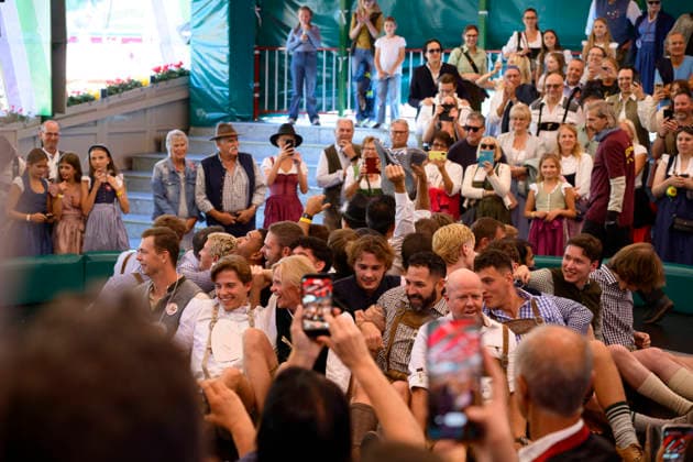 Men on the Devil s Wheel at the Oktoberfest Wiesn amusement ride, Munich, September 23, 2026
