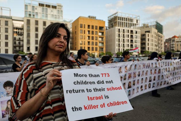 September 23, 2026, Beirut, Beirut, Lebanon: A Lebanese mother holds a banner accusing Israel of killing children as she stands in front of a row of pictures of children died in war between Israel and pro-Iranian Hezbollah war during a candle vigil ceremony in Beirut. Lebanese lawmaker Inaya Ezzeddine, who chairs the Lebanese parliamentÃ¢â‚¬â ¢s Women and Children Committee, said Ã¢â‚¬oenearly 800 children were killed during the two Israeli wars in 2024 and 2026Ã¢â‚¬Â, and around 360,000 displaced. Beirut Lebanon  - ZUMAn313 20260923_zip_n313_007 Copyright: xMarwanxNaamanix