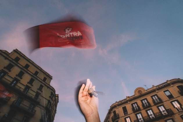 September 23, 2026, Barcelona, Catalonia, Spain: September 23, 2026, Barcelona, Spain: A protester raises a hand as a flag waves overhead at dusk. Hundreds of people gathered in front of the Spanish Government Delegation in Catalonia, on Mallorca Street in Barcelona, at a protest against evictions called by tenants and housing unions, including the Sindicat de Llogateres, the Barcelona Tenants Union. The protest followed the eviction that morning in Madrid of MARICARMEN, an 87-year-old woman forced out of the rented flat where she had lived for seventy years, and the death of OLGA, a woman from L Hospitalet de Llobregat who took her own life after being evicted. The unions warned that they will call a general strike if the Spanish governm  - ZUMAs392 20260923_zip_s392_010 Copyright: xFabianxSuspensivox