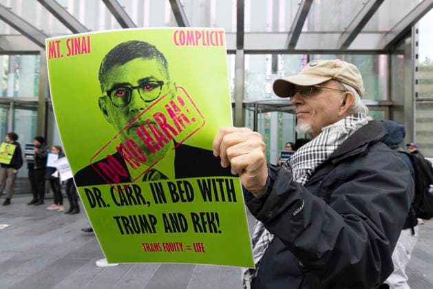 September 23, 2026, New York, New York, USA: A protester holds a sign that reads MT SINAI COMPLICIT DO NO HARM! DR. CARR, IN BED WITH TRUMP AND RFK TRANS EQUITY equals LIFE with an image of Dr. Carr. ACT UP NY leads a coalition of organizations blockading the entrance to 1 WTC and later blocking traffic on the West Side Highway demonstrating under the banner AI OUT OF OUR HEALTHCARE! PALANTIR OUT OF MOUNT SINAI! as the Newsweek AI Health Summit is held inside the building and a keynote speaker is Dr. Brendan Carr, (not pictured) CEO of Mount Sinai. Approximately 20 protesters are arrested by NYPD. Part of the MONEY FOR AIDS and HEALTHCARE! NOT FOR ICE and WARFARE! ACT UP (AIDS Coalition To Unleash Power) campaign, demonstrators denounce  - ZUMAr174 20260923_znp_r174_010 Copyright: xGinaxMxRandazzox