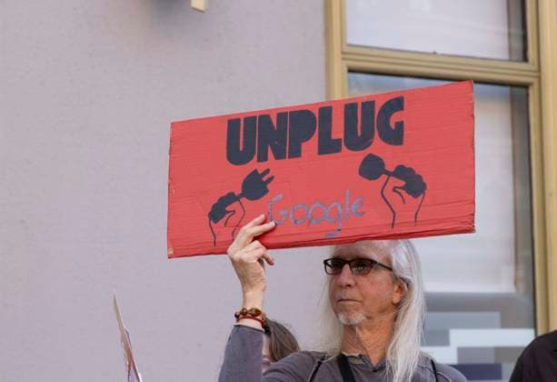 September 23, 2026, New York, New York, USA: A person stands outside GoogleÃ¢â‚¬â ¢s offices in ManhattanÃ¢â‚¬â ¢s Chelsea neighborhood holding a sign that reads UNPLUG Google. A coalition of climate groups hold a family friendly singing demonstration protesting Google for embedding AI in educational tools and building gas powered data centers fueling the climate crisis. The event is part of the Unplug AI Week of Action during Climate Week NYC. Organizers call for a pause on advanced AI development and data center expansion and a national moratorium on the use of AI in schools. New York USA  - ZUMAr174 20260923_znp_r174_061 Copyright: xGinaxMxRandazzox
