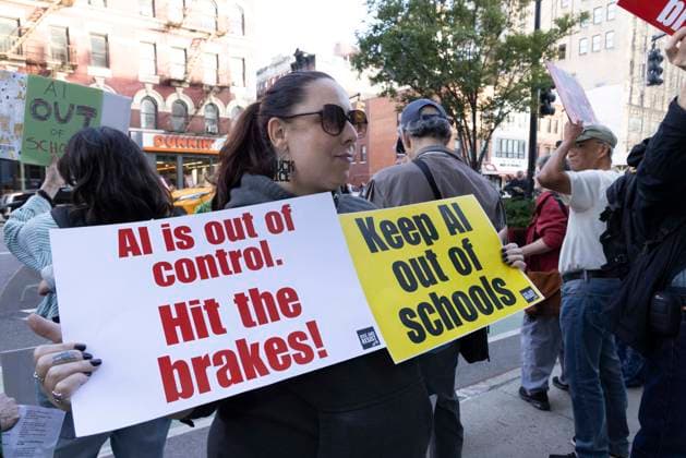 September 23, 2026, New York, New York, USA: A person holds signs reading AI is out of control. Hit the brakes! Keep AI out of schools as employees exit Goggle s offices in ManhattanÃ¢â‚¬â ¢s Chelsea neighborhood at the end of their workday. A coalition of climate groups hold a family friendly singing demonstration protesting Google for embedding AI in educational tools and building gas powered data centers fueling the climate crisis. The event is part of the Unplug AI Week of Action during Climate Week NYC. Organizers call for a pause on advanced AI development and data center expansion and a national moratorium on the use of AI in schools. New York USA  - ZUMAr174 20260923_znp_r174_070 Copyright: xGinaxMxRandazzox