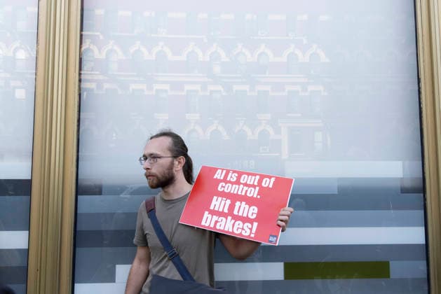 September 23, 2026, New York, New York, USA: A person stands outside GoogleÃ¢â‚¬â ¢s offices in ManhattanÃ¢â‚¬â ¢s Chelsea neighborhood holding a sign that reads AI is out of control. Hit the brakes! A coalition of climate groups hold a family friendly singing demonstration protesting Google for embedding AI in educational tools and building gas powered data centers fueling the climate crisis. The event is part of the Unplug AI Week of Action during Climate Week NYC. Organizers call for a pause on advanced AI development and data center expansion and a national moratorium on the use of AI in schools. New York USA - ZUMAr174 20260923_znp_r174_073 Copyright: xGinaxMxRandazzox