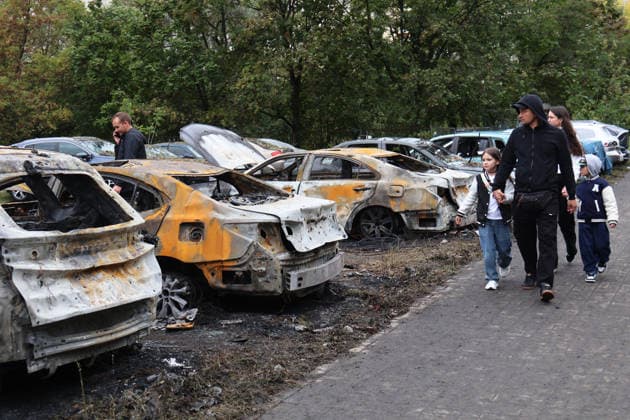People walk past burnt-out cars at a parking lot in the Podilskyi district after an overnight Russian attack, Kyiv, Ukraine, September 24, 2026. On Thursday night, September 24, Russian forces launched a ballistic missile strike on Kyiv, followed by drone assaults on the capital and region. By morning, two people were confirmed killed and eight injured. The attack caused fires and destruction across several districts, damaging medical facilities, apartment blocks, private homes, and vehicles. The maternity hospital in the Podilskyi district sustained damage to windows, doors, and parts of the facade from the first to fifth floors, as well as to windows in the laundry and boiler rooms. Patients, children, and medical staff were unharmed, hav  Copyright: xPavloxBahmutx