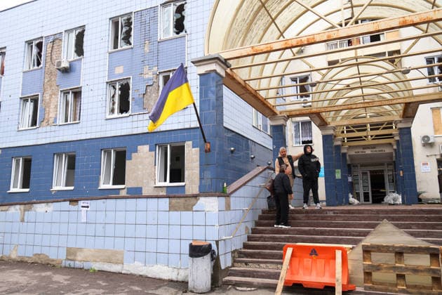 A security guard, a man and a woman stand on the porch of the Consultative and Diagnostic Centre in the Podilskyi district, damaged by an overnight Russian attack, Kyiv, Ukraine, September 24, 2026. On Thursday night, September 24, Russian forces launched a ballistic missile strike on Kyiv, followed by drone assaults on the capital and region. By morning, two people were confirmed killed and eight injured. The attack caused fires and destruction across several districts, damaging medical facilities, apartment blocks, private homes, and vehicles. The maternity hospital in the Podilskyi district sustained damage to windows, doors, and parts of the facade from the first to fifth floors, as well as to windows in the laundry and boiler rooms. Pa  Copyright: xPavloxBahmutx