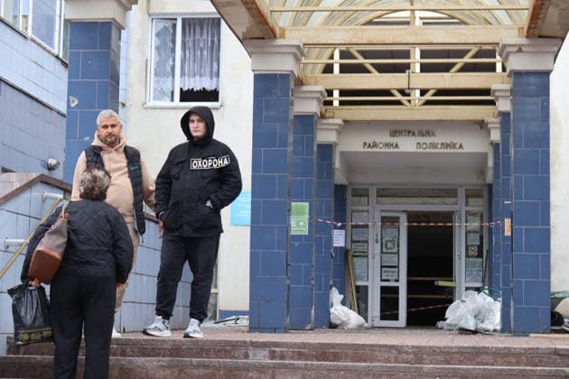 A security guard, a man and a woman stand on the porch of the Consultative and Diagnostic Centre in the Podilskyi district, damaged by an overnight Russian attack, Kyiv, Ukraine, September 24, 2026. On Thursday night, September 24, Russian forces launched a ballistic missile strike on Kyiv, followed by drone assaults on the capital and region. By morning, two people were confirmed killed and eight injured. The attack caused fires and destruction across several districts, damaging medical facilities, apartment blocks, private homes, and vehicles. The maternity hospital in the Podilskyi district sustained damage to windows, doors, and parts of the facade from the first to fifth floors, as well as to windows in the laundry and boiler rooms. Pa  Copyright: xPavloxBahmutx