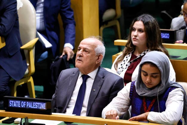 Ambassador Dr. Riyad Mansour, Permanent Observer of the State of Palestine to the United Nations, center, listens to President of Palestine Mahmoud Abbas give his pre-recorded speech on large screens at the UN General Assembly 81st session General Debate in UN General Assembly Hall at the United Nations Headquarters on Thursday, September 24, 2026 in New York City.  NYP20260924407 PETERxFOLEY