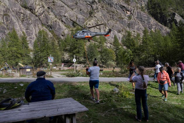 Vehicles Evacuated by Helicopter After Floods - France Residents and officials watch the helicopter land at Ailefroide after the vehicle evacuation. Nine vehicles stranded at the Pre de Madame Carle were evacuated by helicopter after floods on August 28 destroyed several sections of the RD204T access road. Ailefroide, Vallouise-Pelvoux, Hautes-Alpes, France, September 24, 2026. Photo by Thibaut Durand ABACAPRESS.COM vallouise-pelvoux PROVENCE-ALPES-COTE D AZUR France  Copyright: xDurandxThibaut ABACAx
