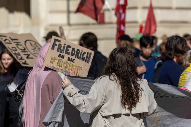 Schulstreik gegen Wehrpflicht in Frankfurt 25.09.2026: Mädchen hält Plakat hoch mit der Aufschrift: Friedrich an die Front , gemeint ist vermutlich Kanzler Friedrich Merz. Schüler und junge Menschen demonstrieren bei einem Schulstreik gegen die Wehrpflicht in Frankfurt am Main. Die Demonstration startete an der Alten Oper und richtet sich gegen eine Wiedereinführung beziehungsweise Ausweitung der Wehrpflicht und verpflichtender Musterungen. Die Teilnehmer fordern unter anderem mehr Mitsprache junger Menschen in der Wehrpflichtdebatte und setzen sich nach Angaben der Veranstalter gegen Militarisierung und für Investitionen in Bildung ein. Der Protest ist Teil bundesweiter Schulstreiks gegen die Wehrpflicht. Frankfurt am Main Alte Oper