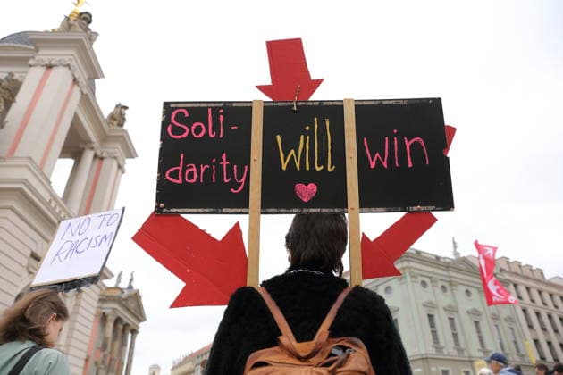 A protester stands outside the state parliament holding a sign that reads Solidarity Will Win during a demonstration against the prepaid card for refugees in Brandenburg, Potsdam, September 25, 2026. Demonstration against the prepaid card in Potsdam