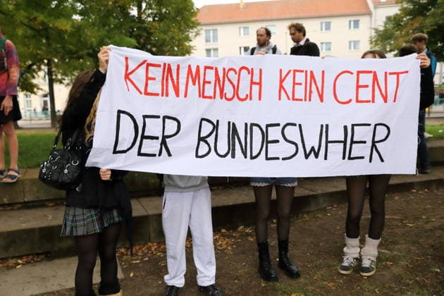 Protesters stand on Unity Square holding a banner reading No People, No Money for the Bundeswehr during a demonstration against the draft, Potsdam, September 25, 2026. School strike against the draft in Potsdam
