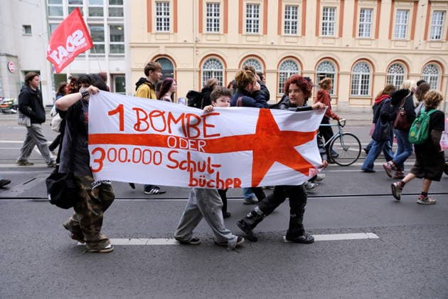 Protesters march down Friedrich-Ebert-Straße carrying a banner reading 1 Bomb or 300,000 Textbooks during a demonstration against the draft, Potsdam, September 25, 2026. School strike against the draft in Potsdam