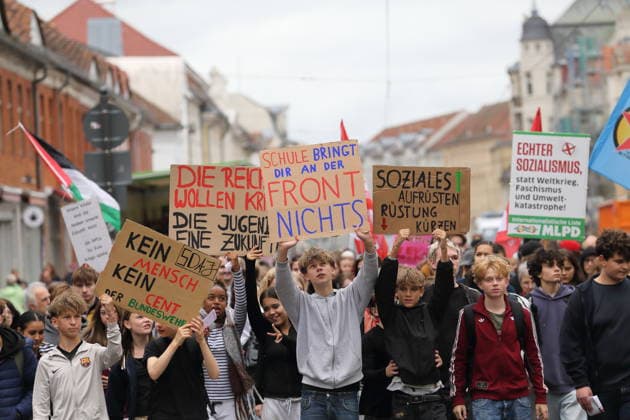 Protesters march with signs reading No People, No Money for the Bundeswehr, The Rich Want War, the Youth Want a Future, School Won’t Help You on the Front Lines, and Boost Social Services, Cut Military Spending on Friedrich-Ebert-Straße during a demonstration against the draft, Potsdam, September 25, 2026. School strike against the draft in Potsdam