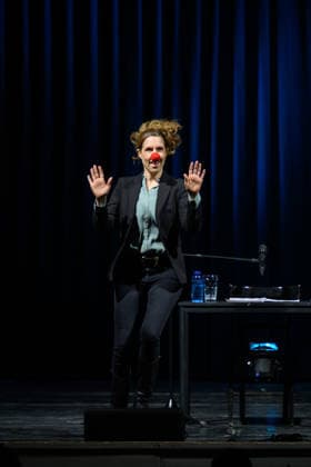 Christine Prayon at the Kulturbeutel Festival in Speyer, Speyer, Germany, September 25, 2026. Cabaret artist Christine Prayon, wearing a red clown nose and with her hands raised, during her show *Abschiedstour* at the opening of the Kulturbeutel Festival in the Alter Stadtsaal.