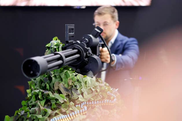 An employee of an emergency vehicle company poses next to a model of a Gatling gun on display at the Euro Defense Expo, the international trade fair for the defense industry, at Messe Essen in Essen, September 25, 2026, North Rhine-Westphalia, Germany Copyright: xChristophxHardtx