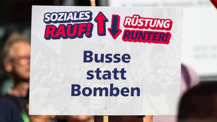 DGB Bavaria: Hard-Earned Mass Rally, Nuremberg, September 26, 2026 A demonstrator holds aloft a sign reading More for social programs, less for military spending—buses instead of bombs. The sign calls for increased social spending and a reduction in military spending. Nuremberg, Bavaria, Germany 20260926-1V9A9834-M4000